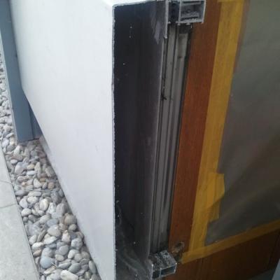 Faserzementplatte unter einer Fassadenplatte aus Aluminium.